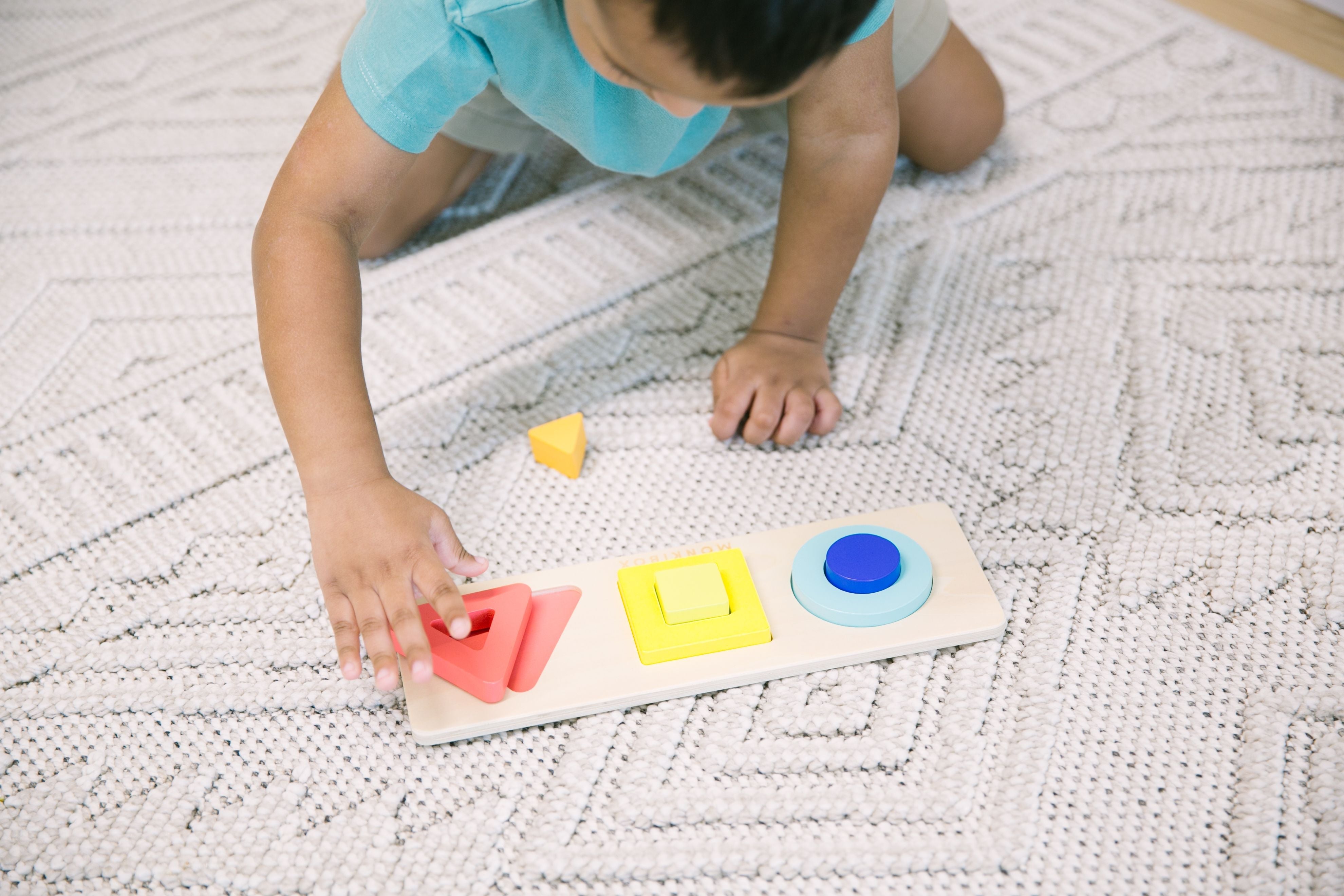 toddler sorting puzzle pieces according to shape and color