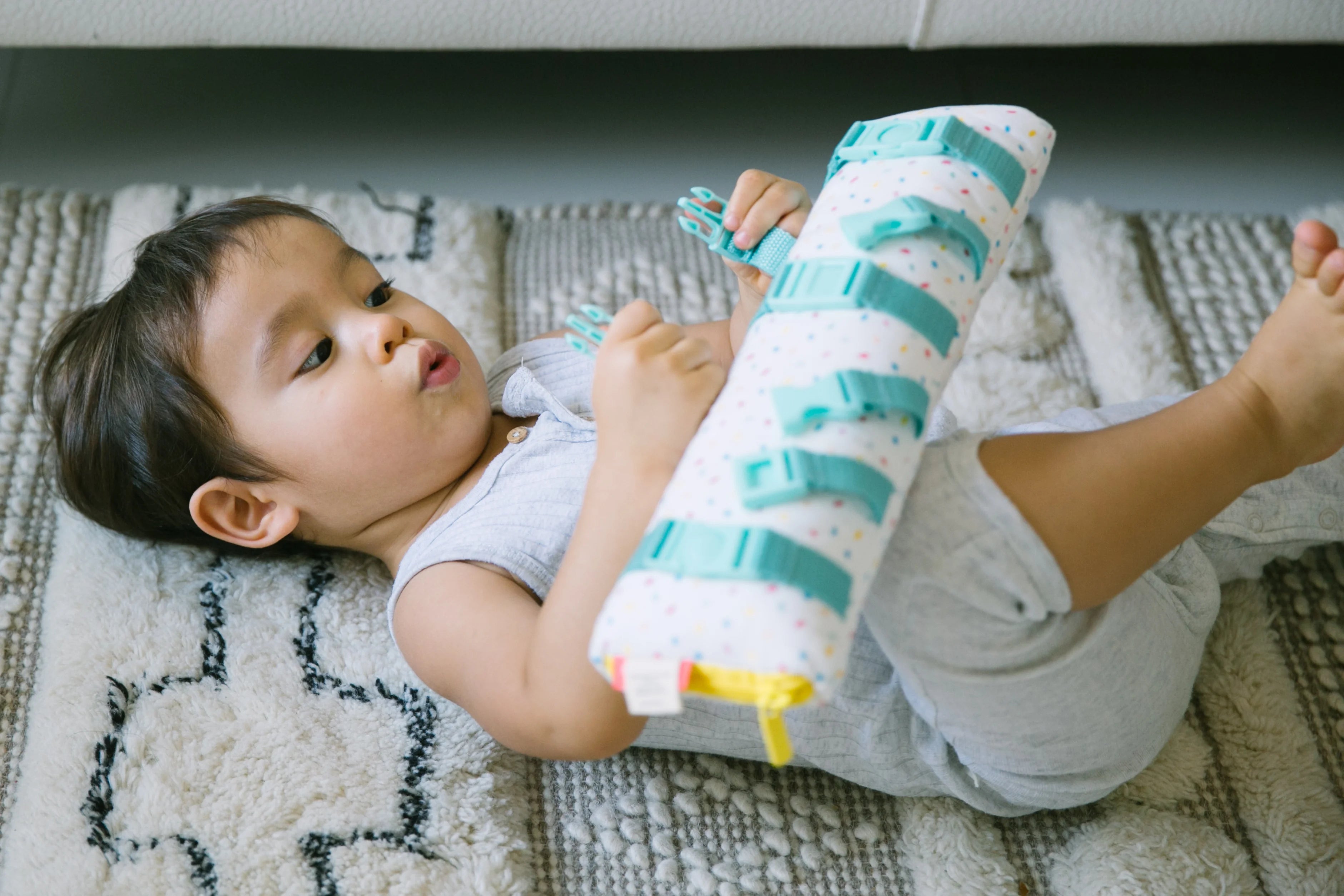 Child lying on the floor with toy