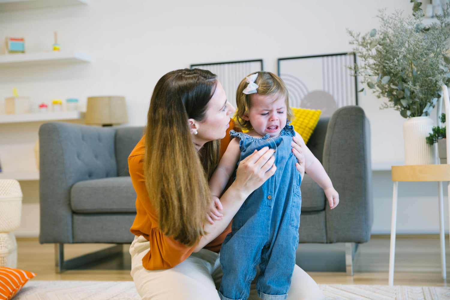 Toddler crying while a parent comforts them, highlighting emotional communication and supportive responses