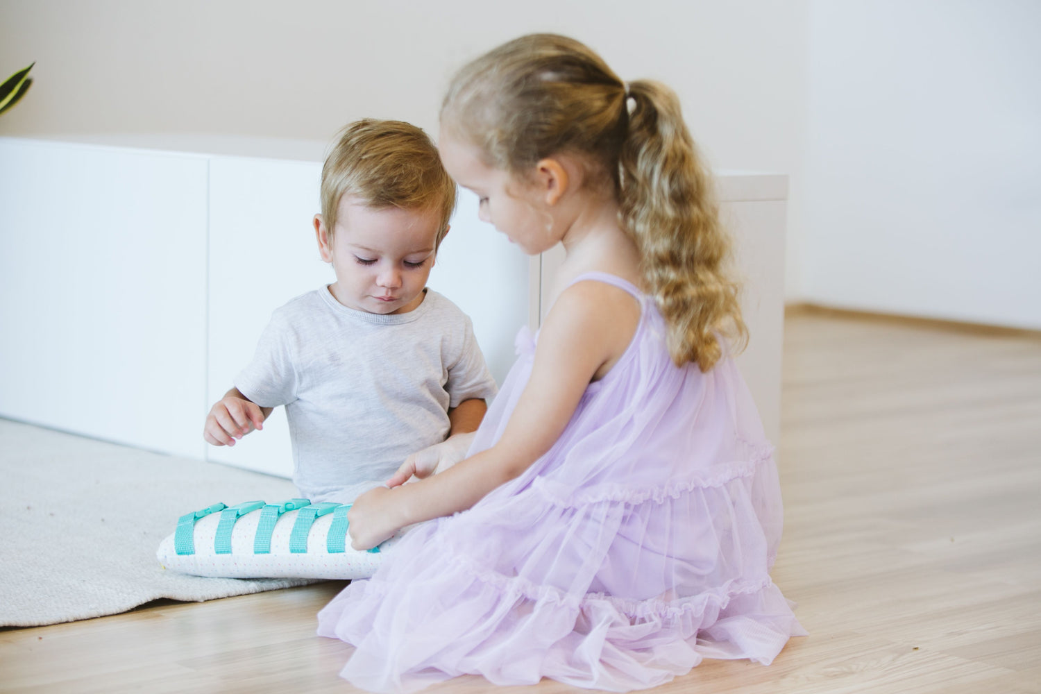 Two toddlers playing together, sharing toys and interacting in a playful and cooperative manner.