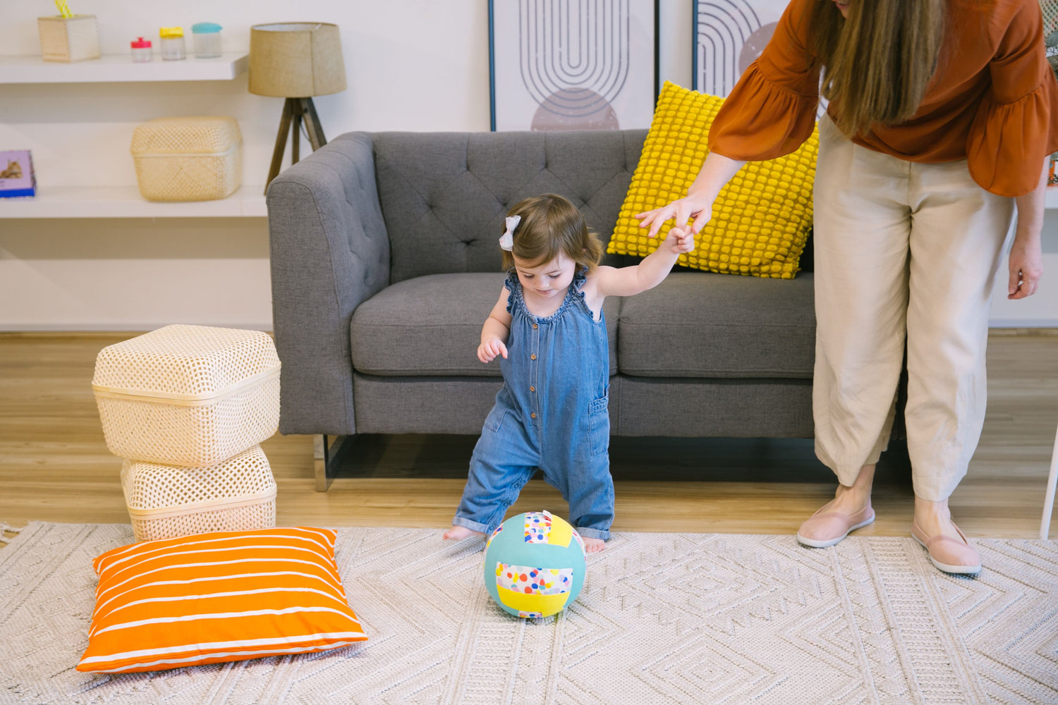 Parent supporting toddler taking their first steps, showcasing social-emotional support during walking milestones