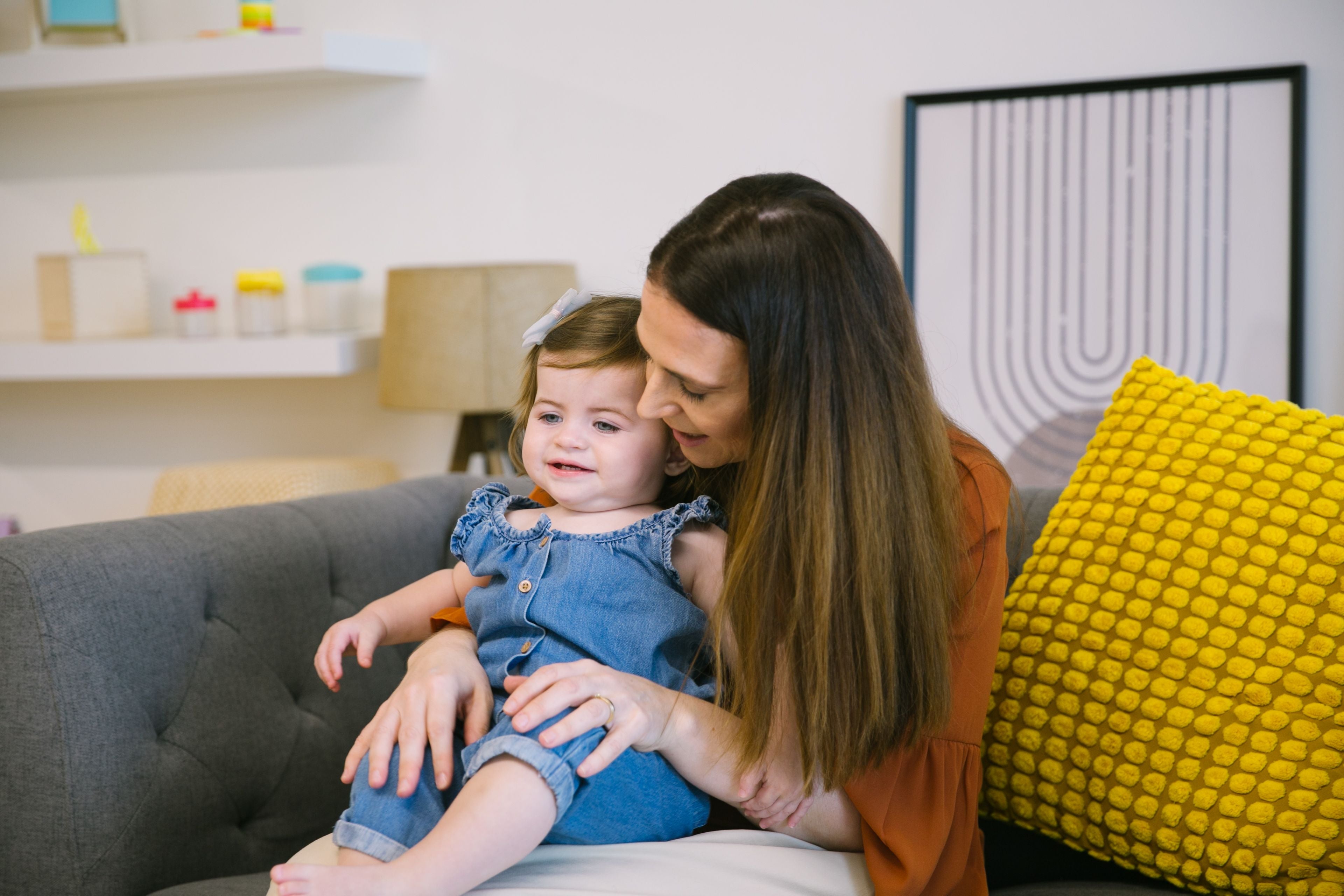 Mom gently touching the denim fabric of toddler’s clothing, showcasing sensory-friendly clothing options